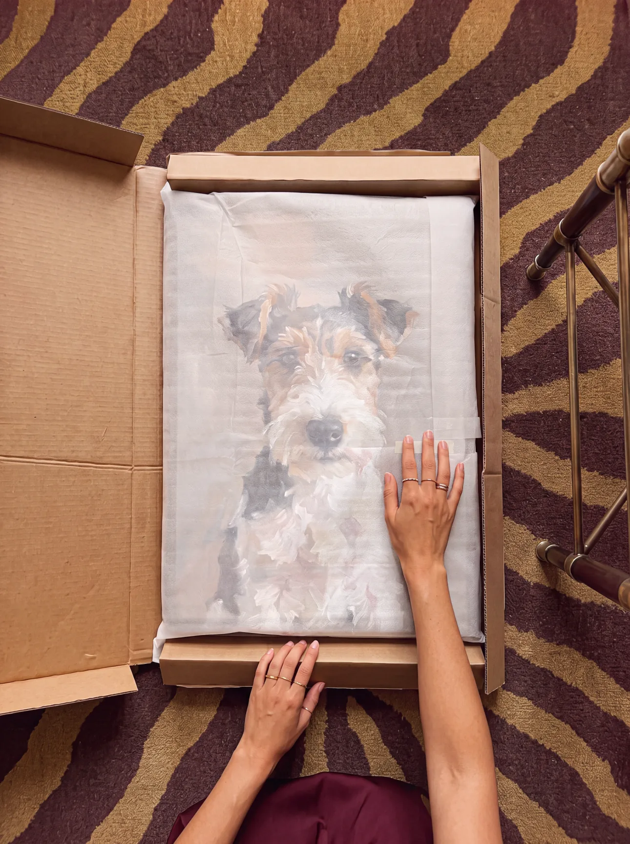 A framed pet portrait protected inside its shipping box